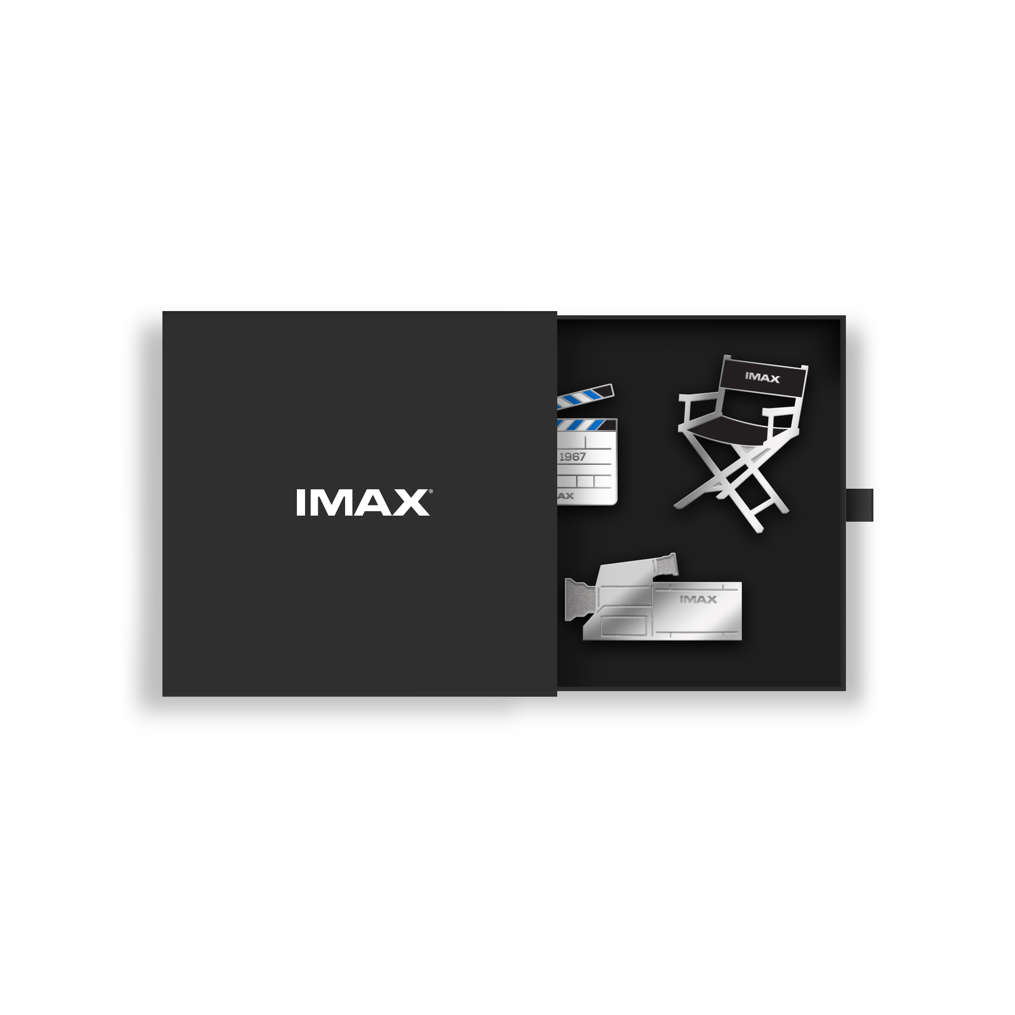 Three silver pins shaped like a director’s chair, an IMAX camera, and a clapper board in a small, black box with a white IMAX logo on the front.