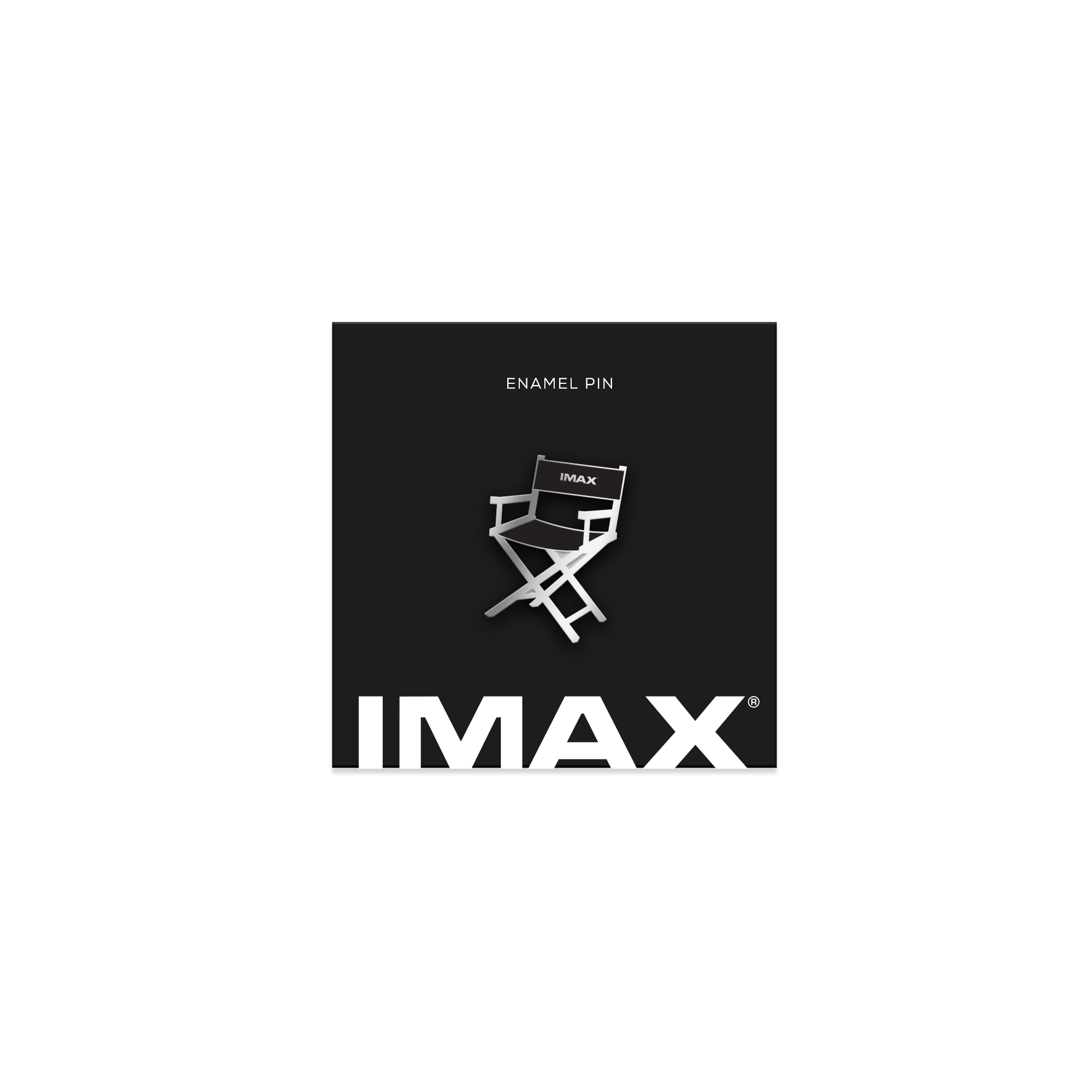 A silver and black pin in the shape of a Director’s chair used on set with the IMAX logo on a black, IMAX-branded backing card.