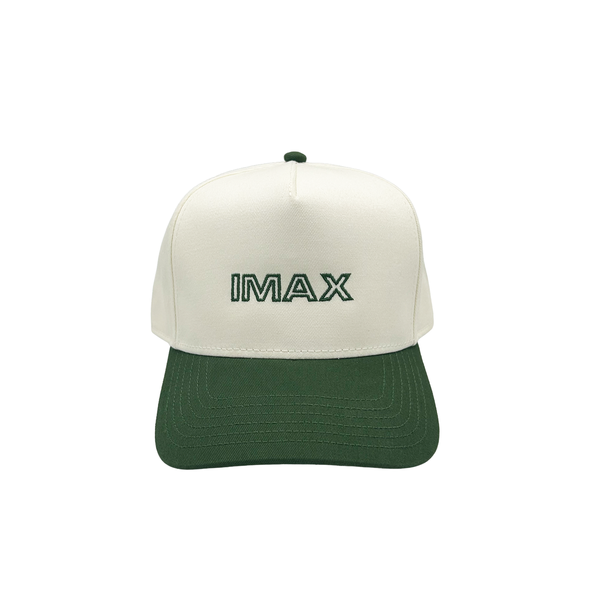 Cream and green cotton baseball style hat hat featuring embroidered IMAX outline logo on the front, curved green brim, and adjustable back strap and embroidered “’67” detail on the side.