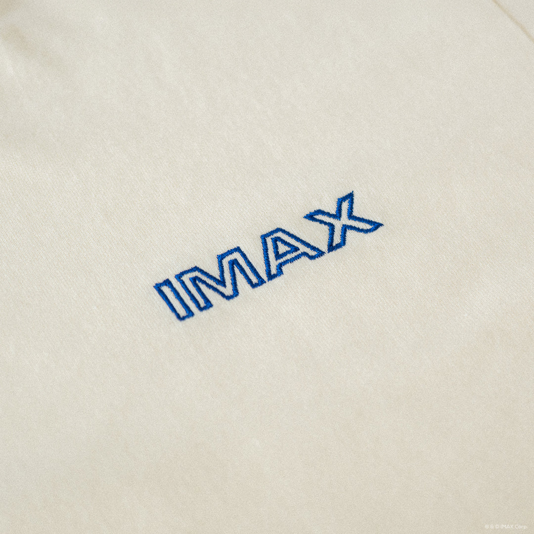 close up shot of the blue imax logo on a cream background of the hat.