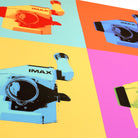 A close-up of a multicolored poster depicting IMAX film cameras placed in various colored boxes.
