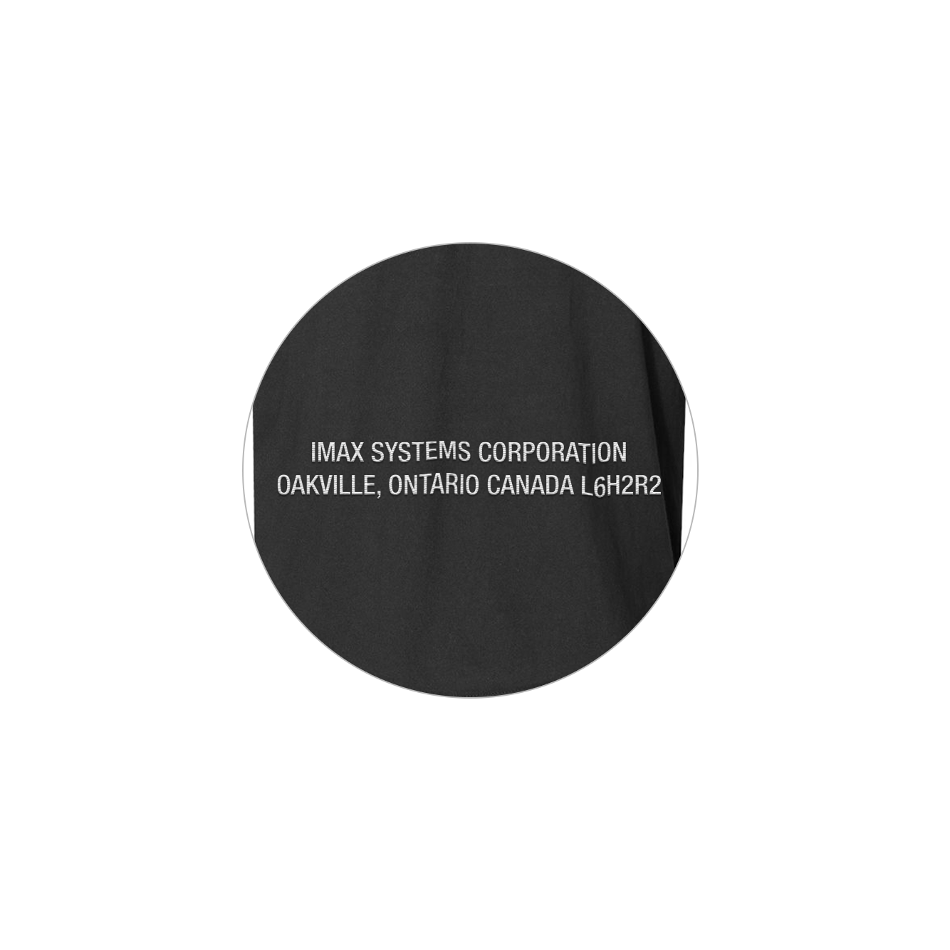 A close-up of the sleeve of the black long-sleeved t-shirt, featuring “IMAX Systems Corporation Oakville, Ontario Canada L6H2R2”