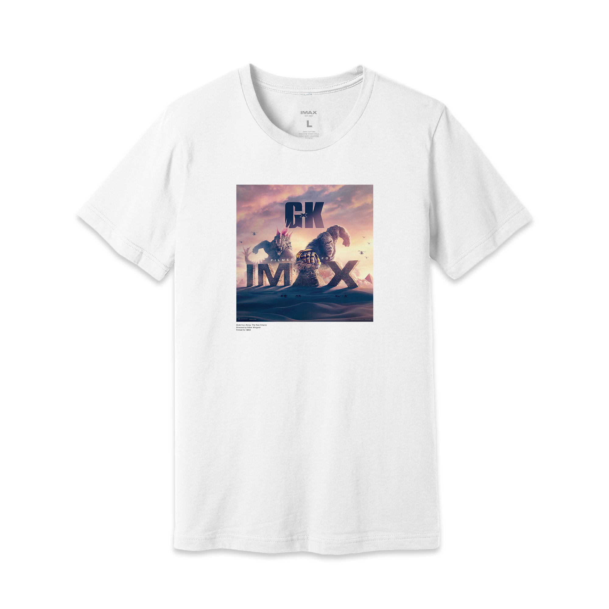 IMAX’s Exclusive Art featuring Godzilla and King Kong battling in the desert on a white T-shirt with a large IMAX logo, inspired by the movie Godzilla x Kong: The New Empire. Underneath, in small black letters is featured “Godzilla x Kong: The New Empire, Directed by Adam Wingard and Filmed for IMAX. 