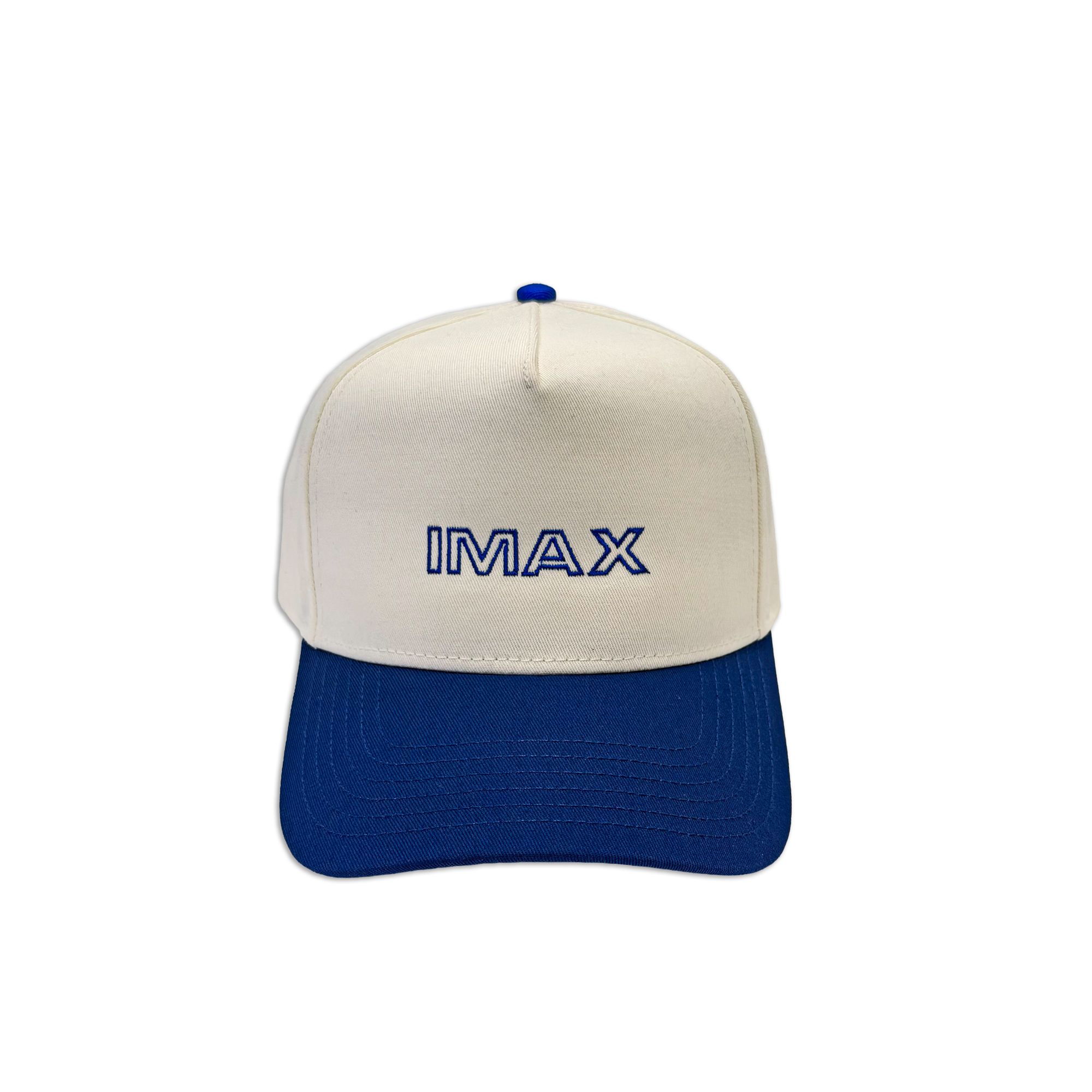 Cream and royal blue cotton dad hat featuring embroidered IMAX outline logo on the front, curved blue brim, and adjustable back strap and embroidered “’67” detail on the side.