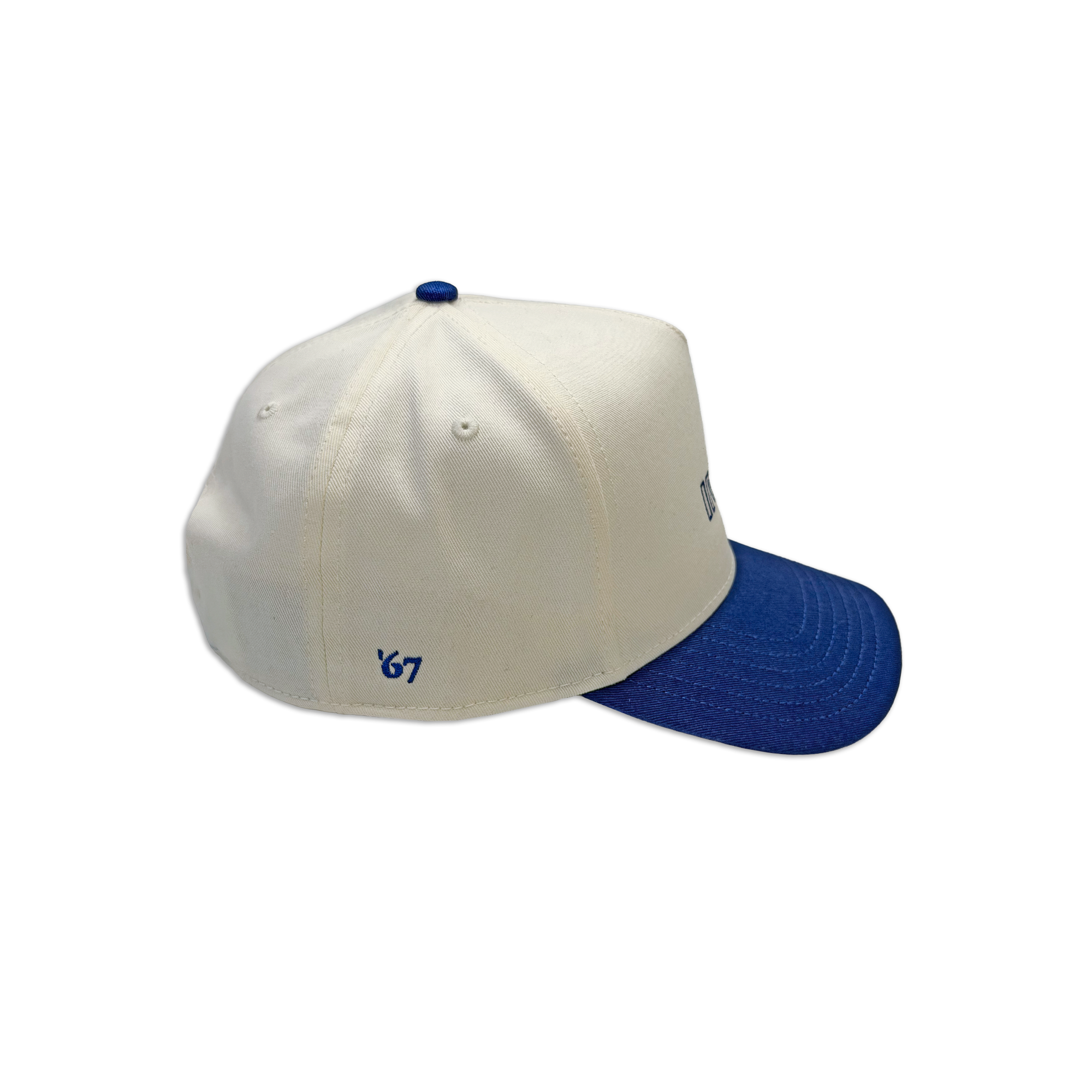 Cream and royal blue cotton dad hat featuring embroidered IMAX outline logo on the front, curved blue brim, and adjustable back strap and embroidered “’67” detail on the side.