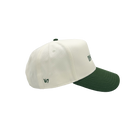 A structured baseball cap with an off-white crown and a dark forest green curved brim, featuring small embroidered green text on the side.