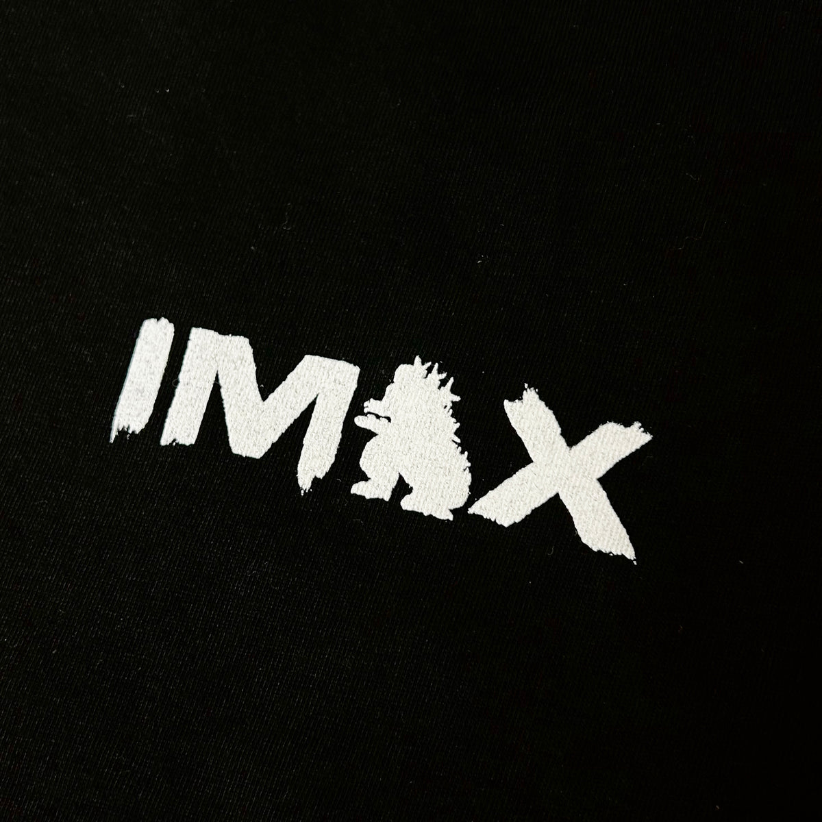 Close up of IMAX text with the A being Godzilla