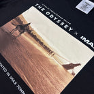 Black t-shirt with 'The Odyssey' IMAX 70mm film poster design.