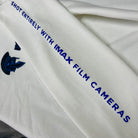 White fabric with blue text and logo, featuring 'IMAX' branding.