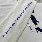 White fabric with blue text and graphics, including 'A Film by Christopher Nolan' and a camera icon.