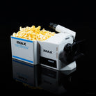IMAX popcorn machine with popcorn on a black background