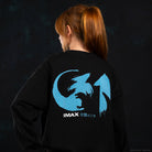 A person shown from behind wearing a black sweatshirt with a large light blue and white IMAX Godzilla graphic on the back, set against a dark textured background.