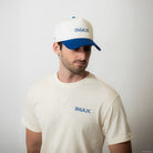 Man wearing a white cap and t-shirt with 'IMAX' logo on a plain background