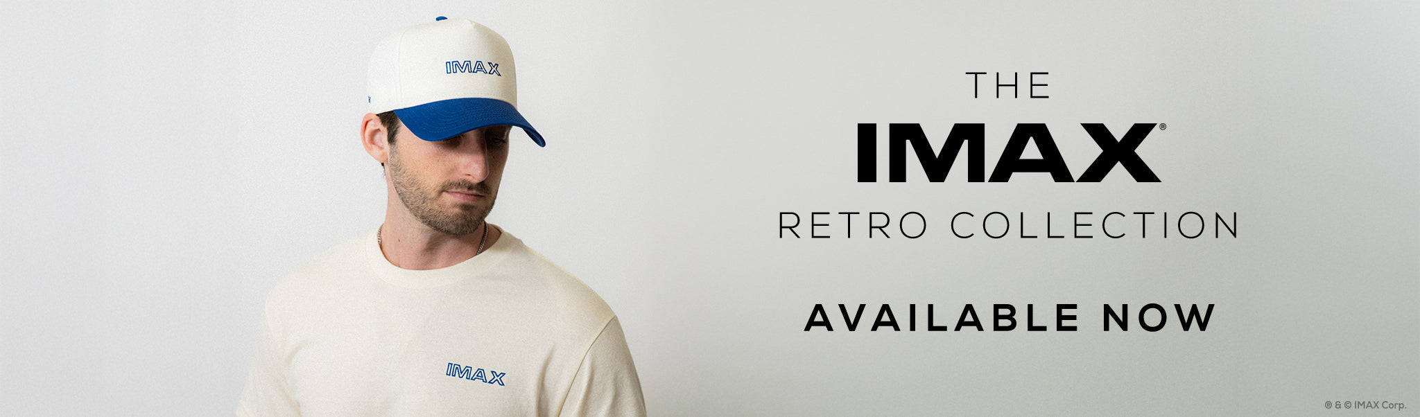 Man wearing an IMAX cap and t-shirt with text 'The IMAX Retro Collection Available Now' on a light gray background