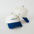 Two white and blue caps with 'IMAX' and '67' text on a light gray background