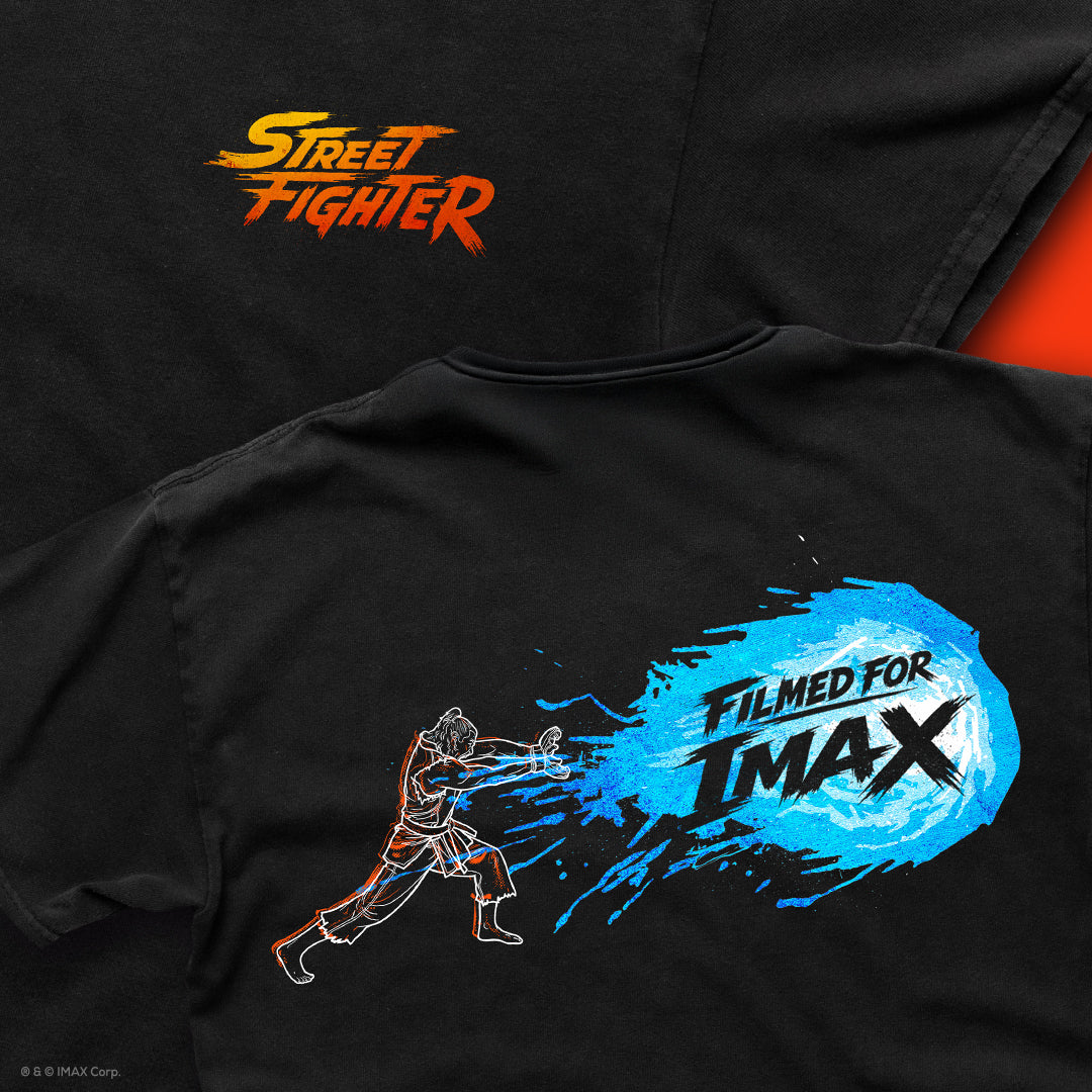 Close up images of the front of the shirt showing the left chest screen print of the  Street Fighter log with the back of the shirt laid over it showing the Haduken fireball with "Filmed For IMAX" in the fireball. 