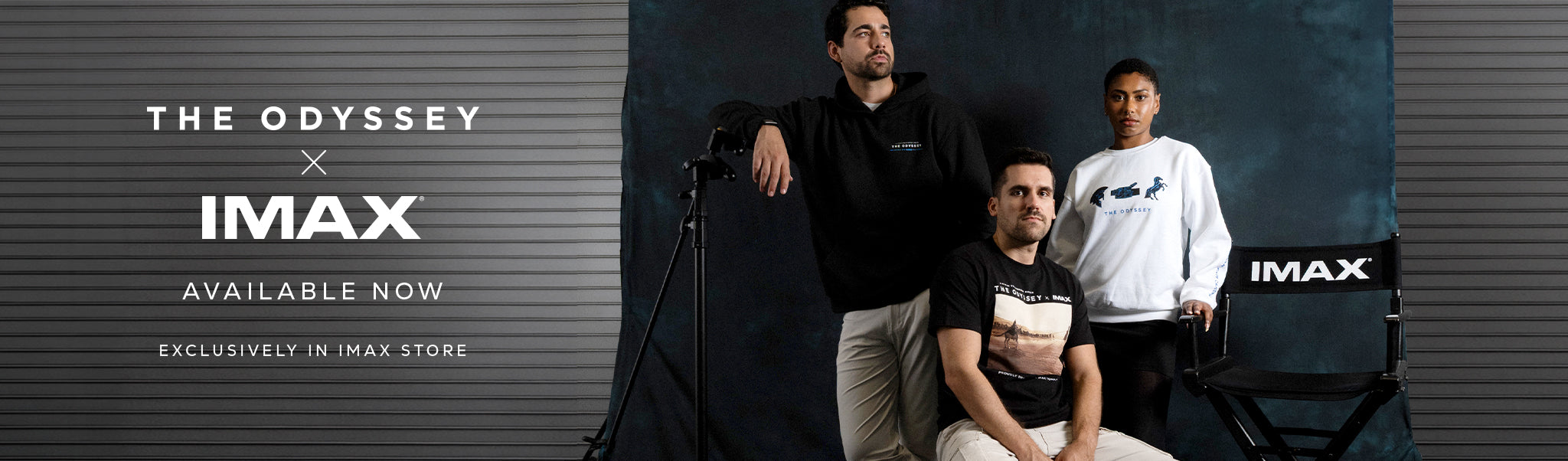 Three people posing wearing The Odyssey movie merch. One person with a black hoodie, one person with a white crew sweater, and one person sitting gwith a black t-shirt. 